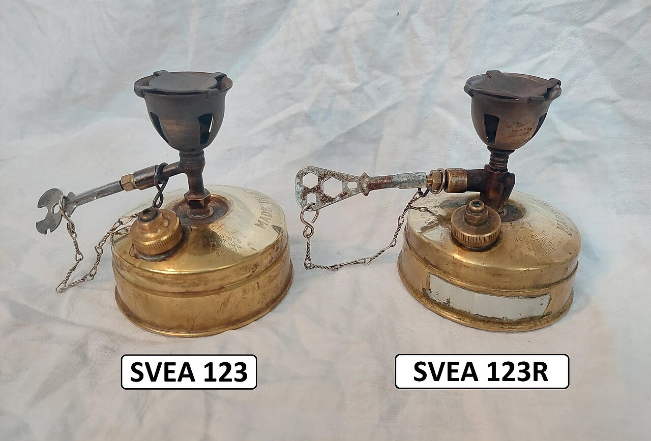 A Svea 123 and Svea 123R brass backpacking stove side by side